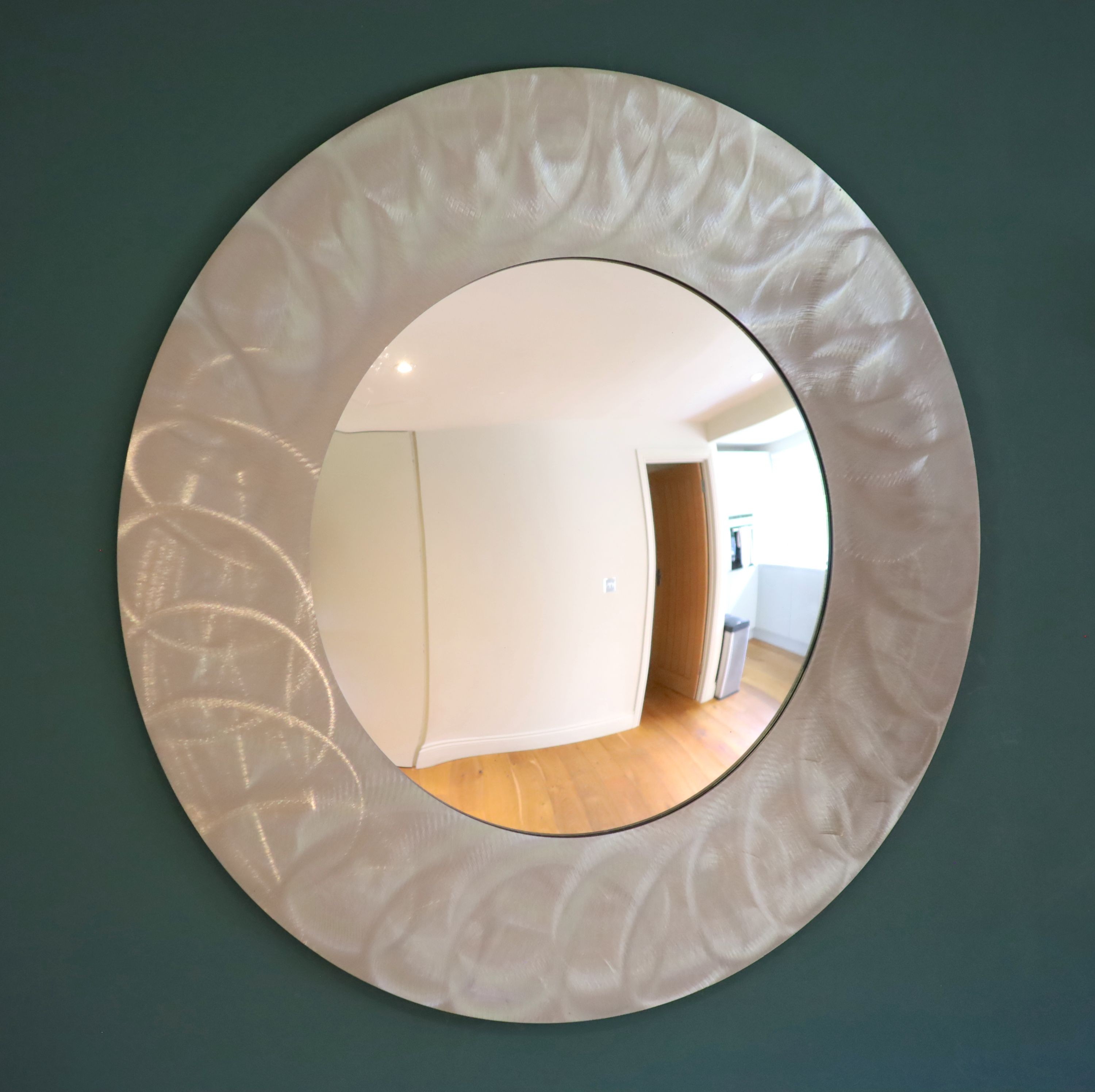 A brushed steel circular wall mirror, 96cm